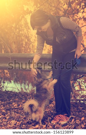 Vintage photo of woman with her dog in autumn park
