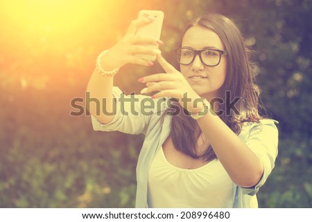 Vintage photo of woman taking a selfie with smart phone