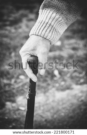 Closeup of old man hand with walking stick