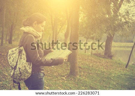 Woman with map in autumn forest