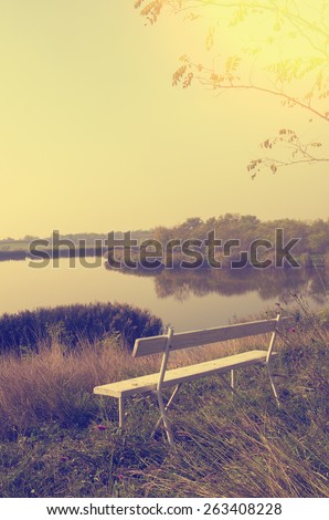 Bench on top of hill. Beautiful landscape in sunset.
