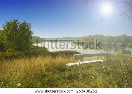 Bench on top of hill. Beautiful landscape in sunset.