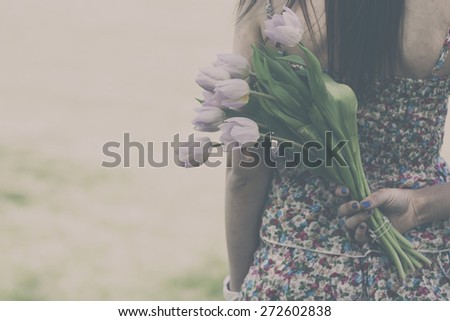 Tulip flowers in woman hand. Analog effected photo.
