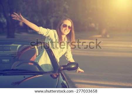 Happy traveler woman in cabrio car