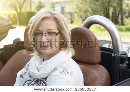 Blonde forty years old woman in cabriolet car