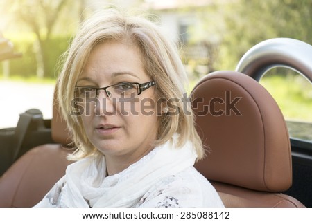 Blonde forty years old woman in cabriolet car