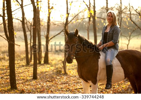 Young beautiful girl with horse in autumn sunset