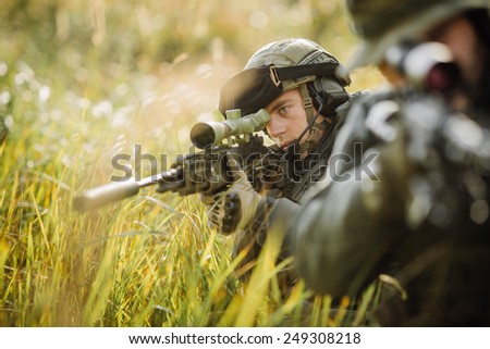 military sniper shooting an assault rifle