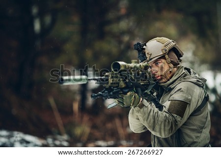 armed  man in camouflage with sniper gun in hands