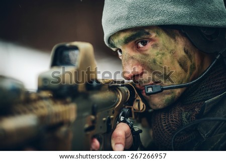 armed  man in camouflage with sniper gun in hands