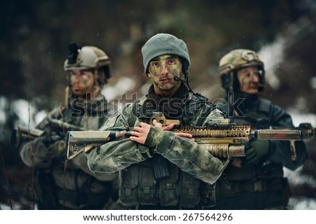 sniper stands with arms and looks forward