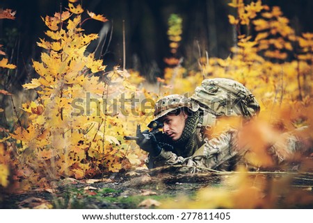 Special forces soldier with rifle in the forest