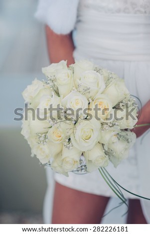 bouquet in hands of the bride of white roses , of close-up