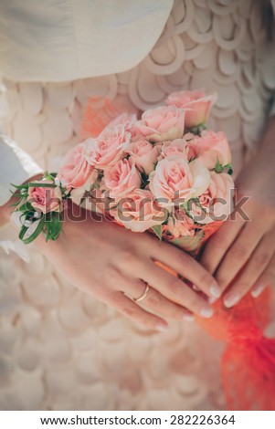 bridal bouquet in hands of the groom   of orange roses gently , of close-up