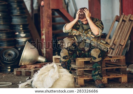 soldier sitting with arms and hands holding her head