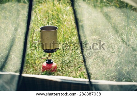 boiling water in titanium mug on portable camping stove