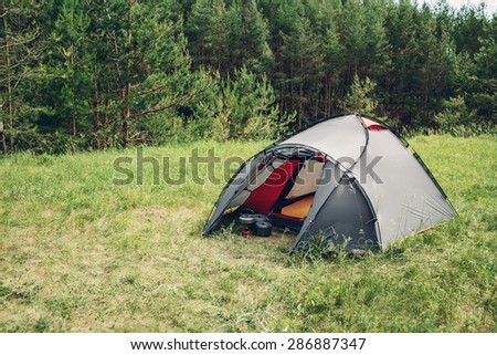 Grey tourist big tent in summer forest