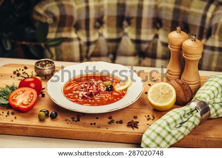 Fragrant meat soup with lemon, olives closeup