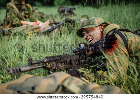 Wounded soldier shoots lying on the grass