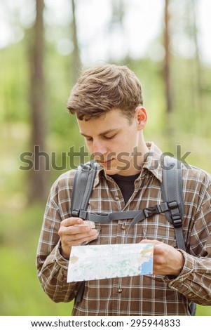 young tourist determine the route map and  compass