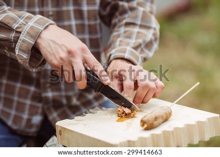 young man are heated in a fire and cook out on a summer forest