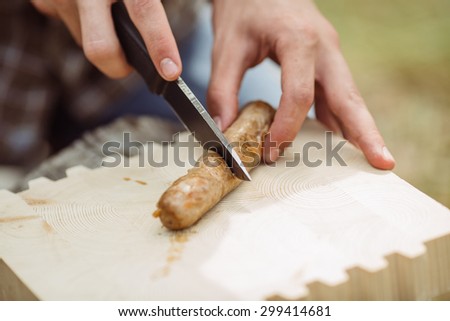 young man are heated in a fire and cook out on a summer forest
