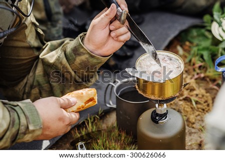 rangers team are heated food on the fire and eat in the forest