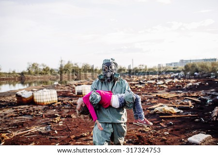 soldier carries a child on the background of ecological disaster