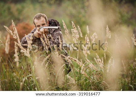 Male hunter in camouflage clothes ready to hunt  with hunting rifle