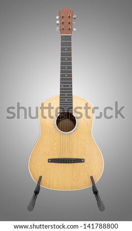 acoustic guitar on stand isolated on gray background