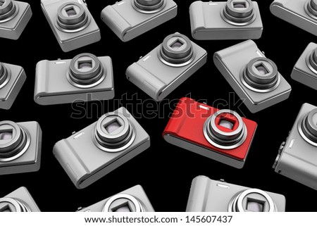 red point and shoot photo camera among gray similar isolated on black background