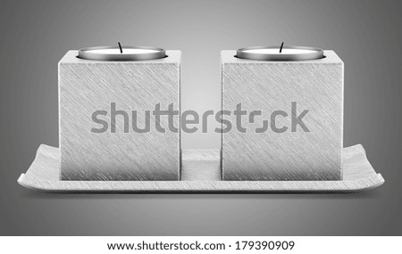 two metallic candlesticks with candles isolated on gray background