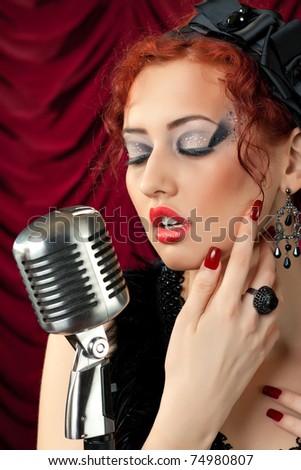 stock photo beautiful redhead woman singing into vintage microphone stock photo beautiful redhead woman singing into vintage microphone