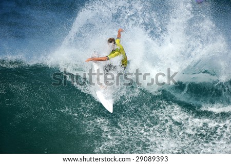A male surfer tears up a big wave with water spraying everywhere.