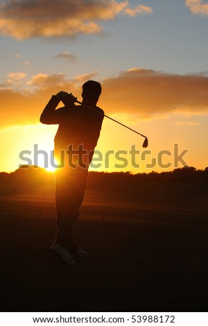 A male golfer enjoys an early round during sunrise.