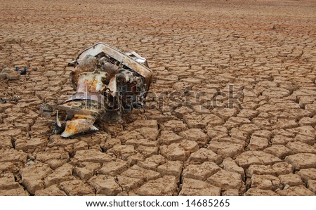Rusty outboard motor in dry lake