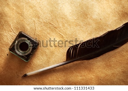 quill pen and inkwell on vintage paper background