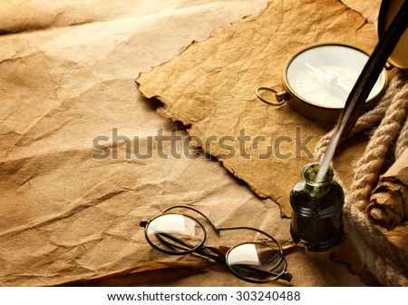 quill pen and vintage spectacles on paper background