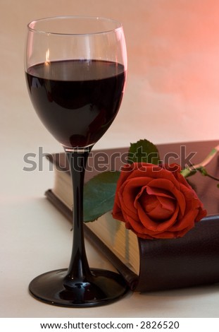 wineglass, rose and book in warm lighting