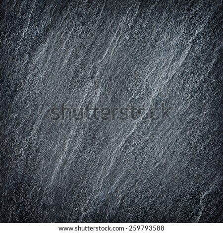 Dark grey / black slate background or texture.
