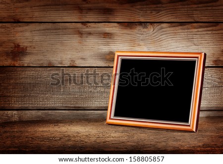Empty wooden picture frame on a wooden table
