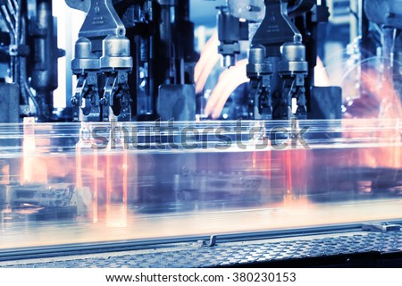Moving assembly line for production of bottles toned in blue