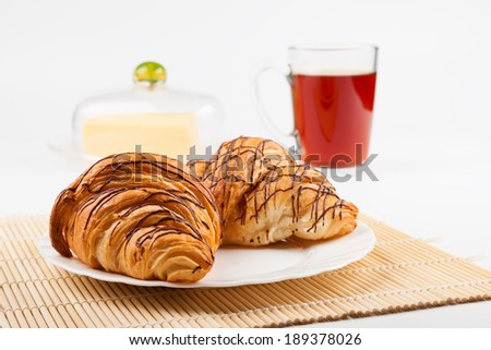Two croissant and a cup of black tea. Shallow depth of field