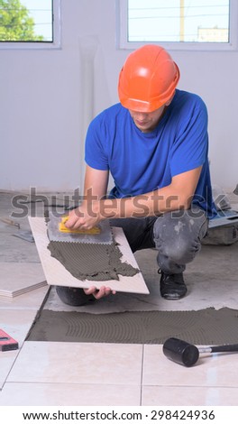 industrial tiler builder worker installing floor tile
