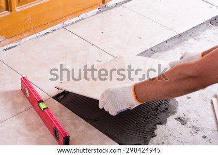 Tiler installing ceramic tiles on a floor