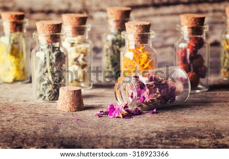 Nature medicine . Herbs in bottles on wooden background .