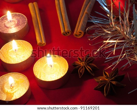 Candle, cinnamon sticks and anise stars on table