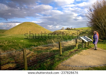 AVEBURY, UK - MARCH 27, 2009:  Visitors reading interpretive signs at Neolithic site of Silbury Hill, near Avebury in Wiltshire, UK