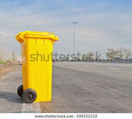 Yellow clean garbage bin on highway