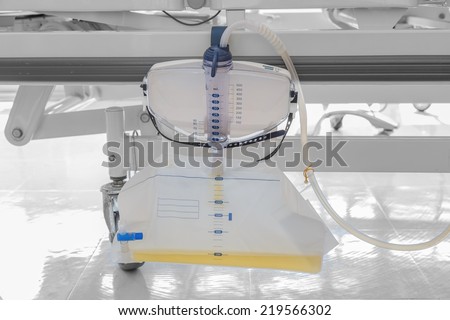 Plastic urine bag hanging under patient bed in hospital